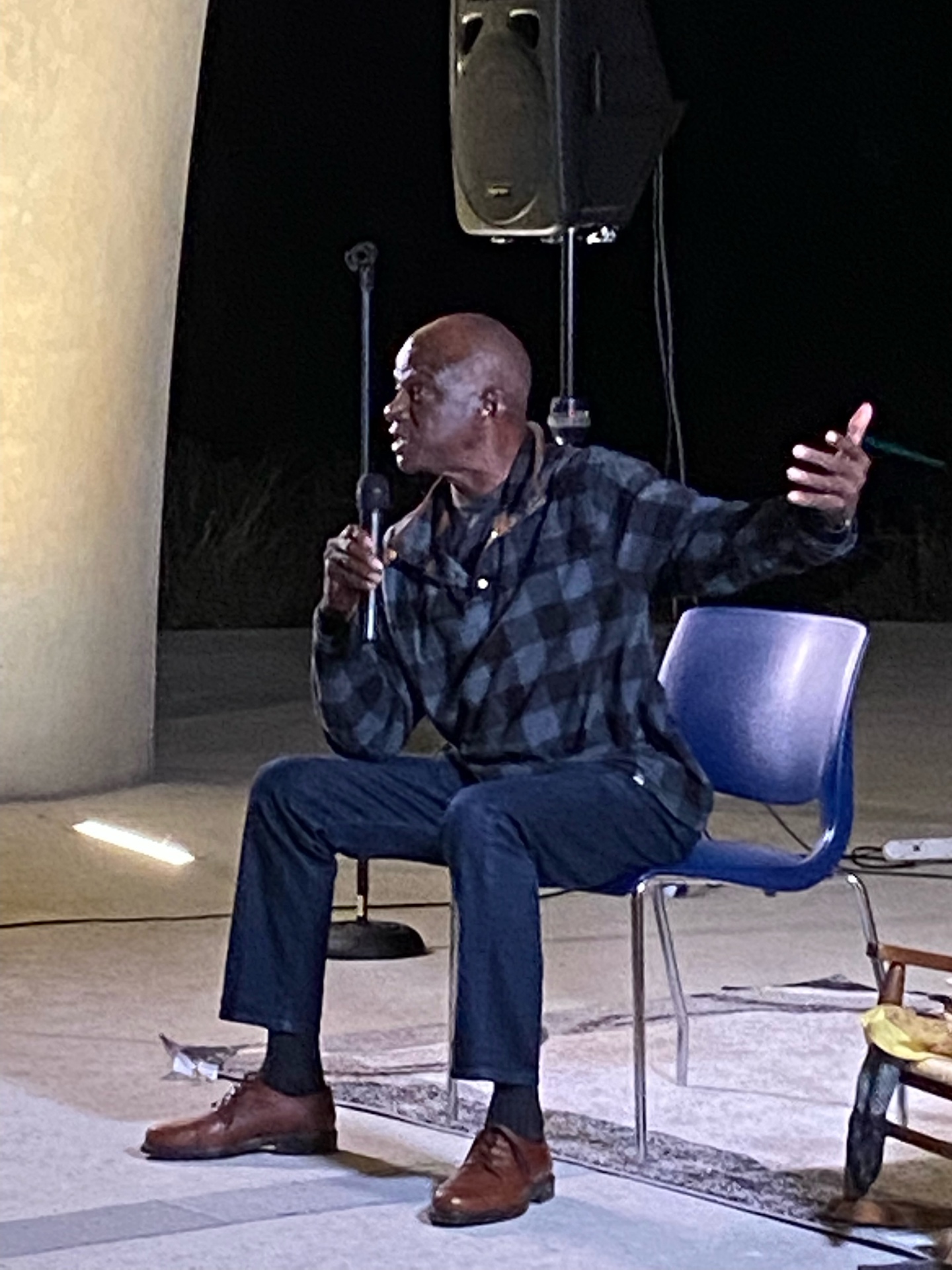 Michael seated on stage with a microphone
